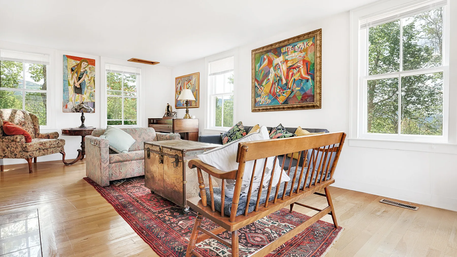 A bright living room with seating arranged around a rug and coffee table.