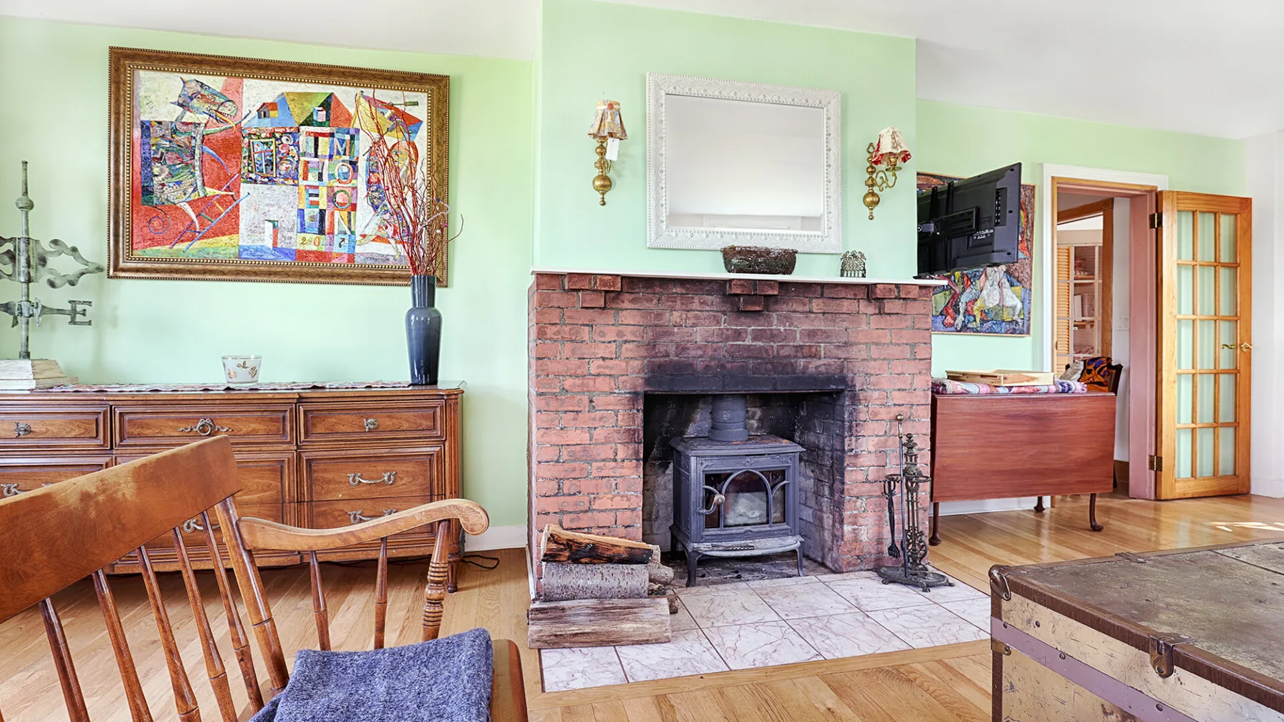 A living room with a brick fireplace and wood-burning stove.