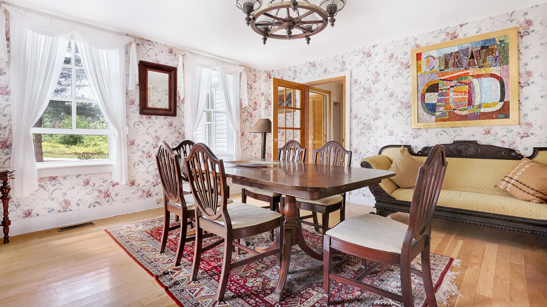 A dining room with a wooden table and chairs beside a living area.