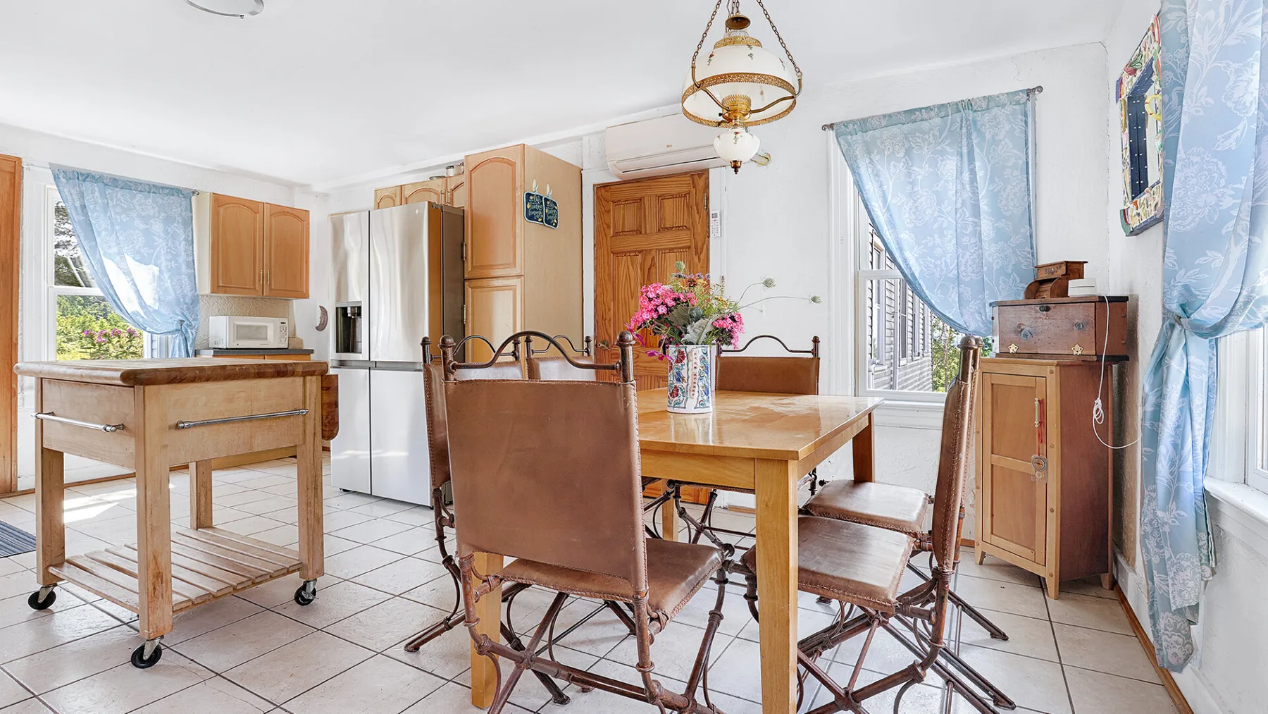 A dining area with a wooden table and chairs beside the kitchen.