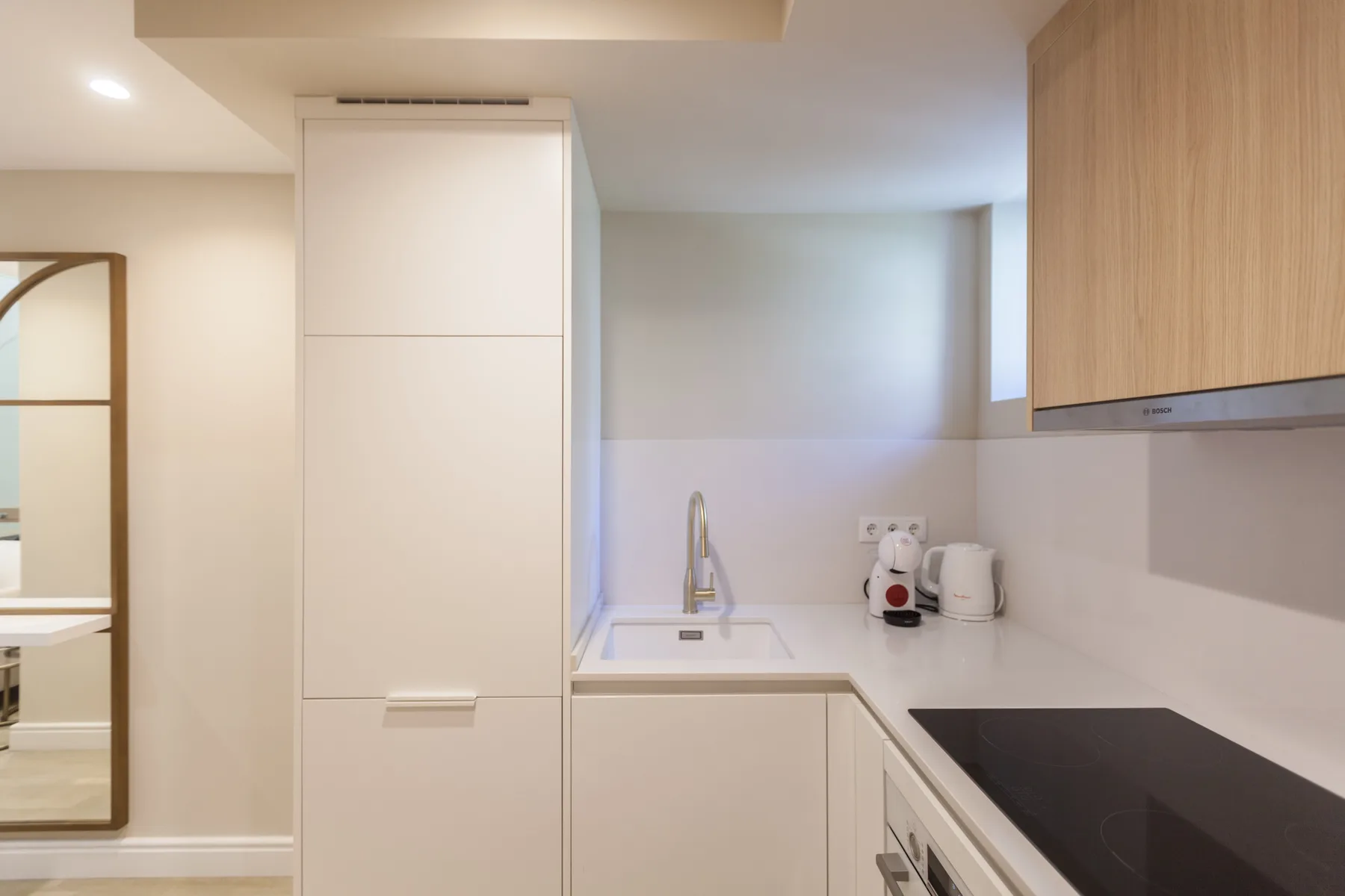 A compact kitchen with a sink, countertop, and built-in cooktop.