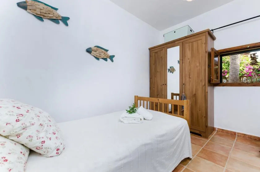 A bedroom with a bed and wooden wardrobe.