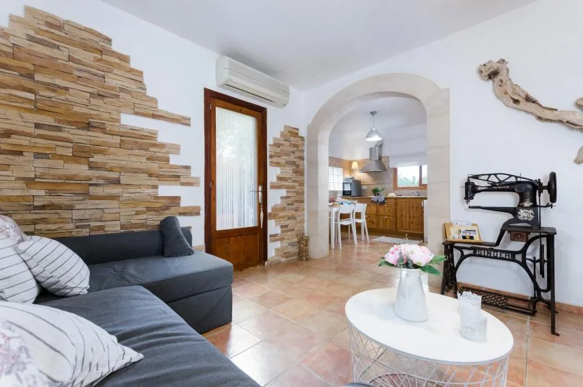A living room with a gray seating area and an arched opening to the kitchen.