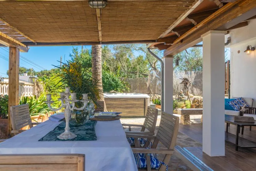 A shaded outdoor dining area opens onto a leafy garden.