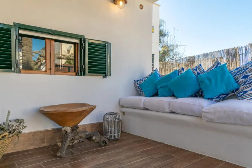 A patio seating area with a built-in bench and bright blue cushions.