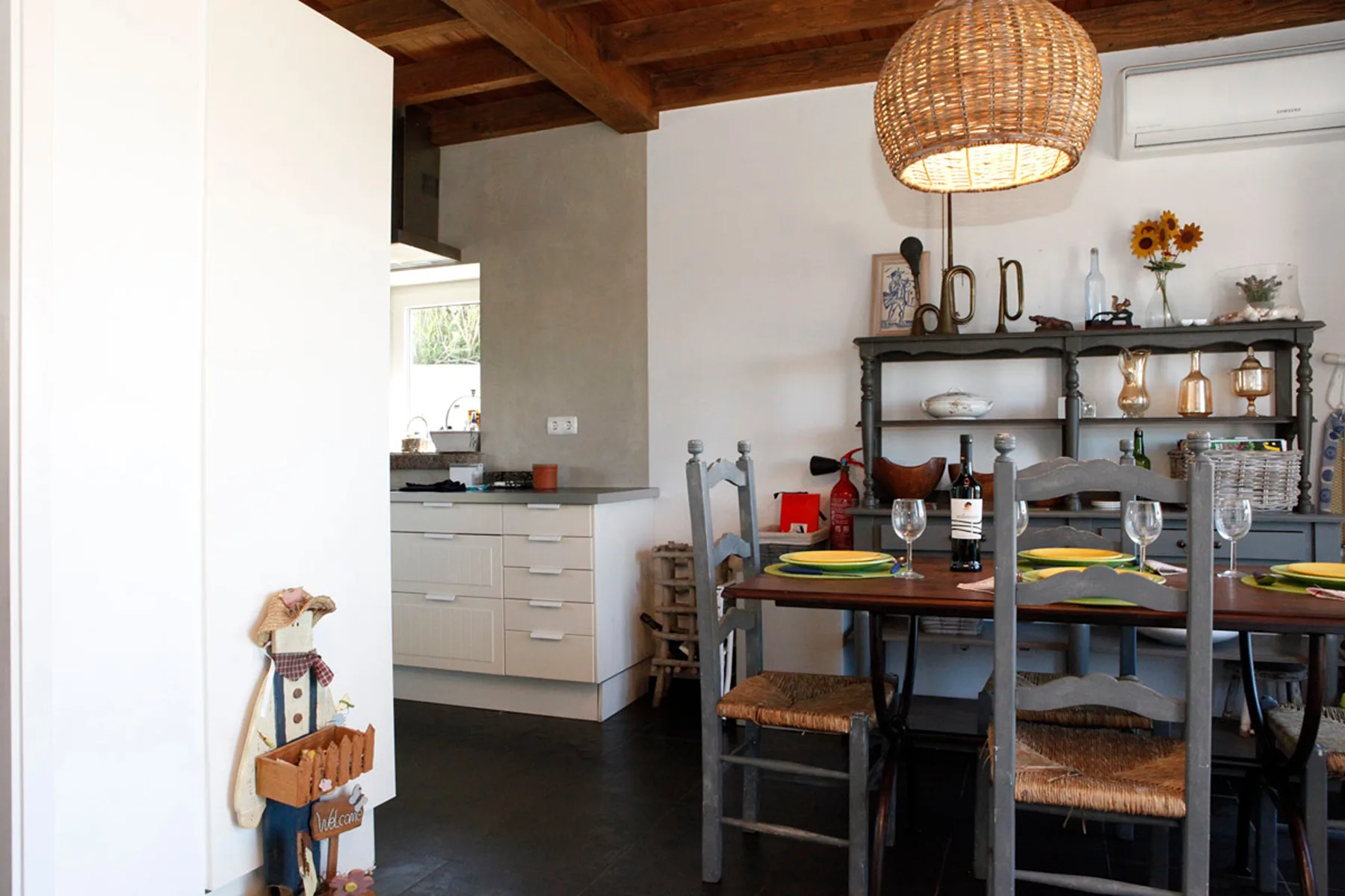 A dining area with a wooden table and chairs beneath a pendant light.