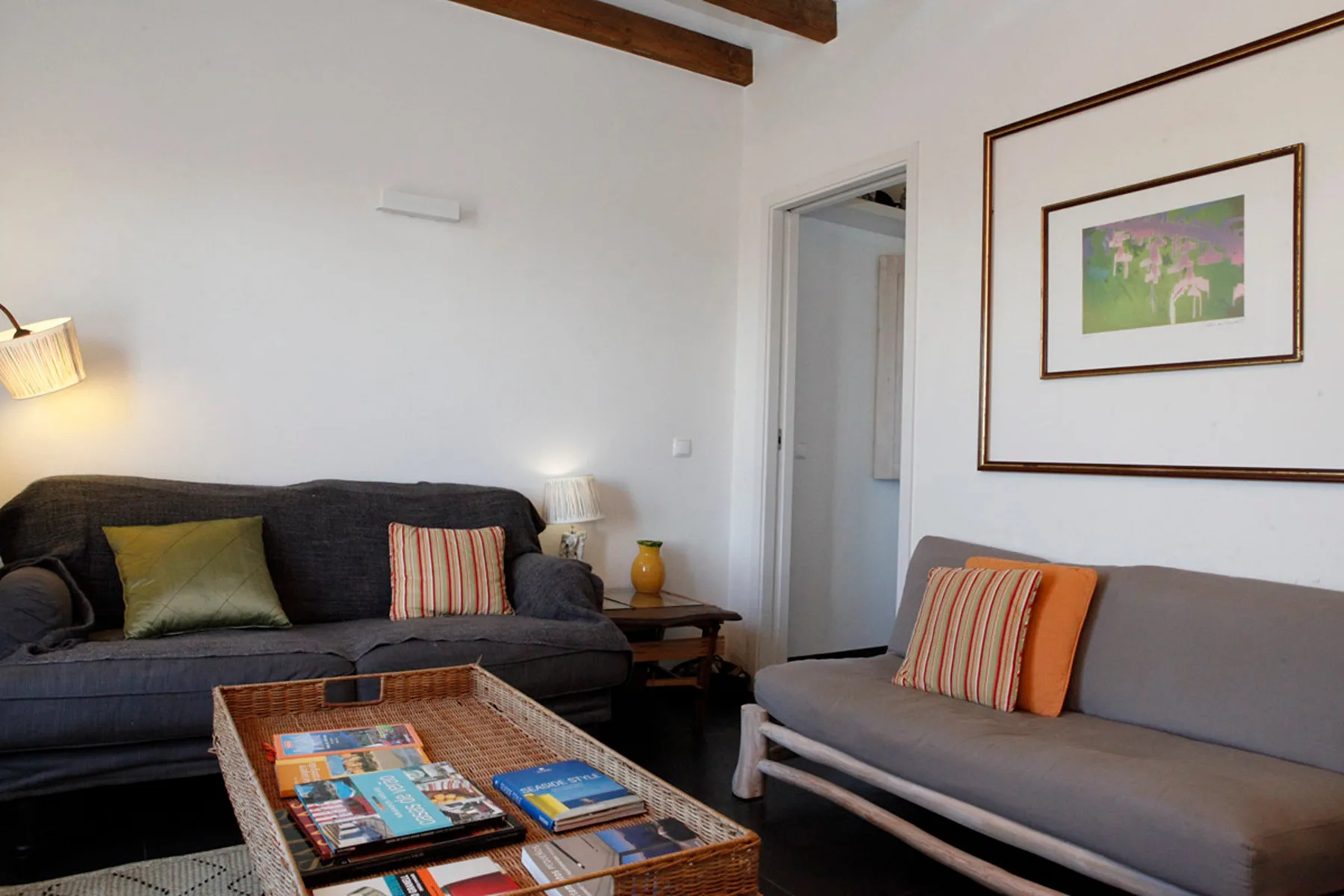 Living room with dark seating, a coffee table, and framed artwork.
