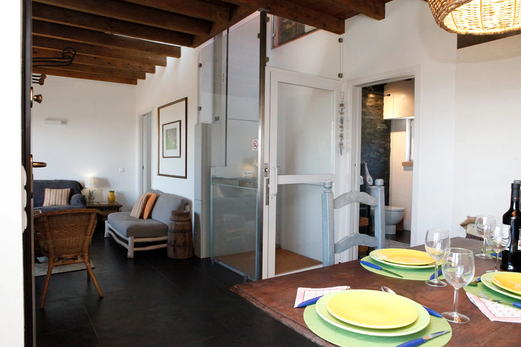 Interior dining area with a set table and lounge seating in the background.