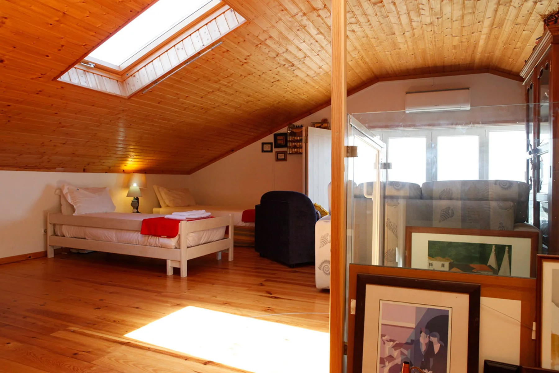 A wood-paneled living room with seating and a skylight.