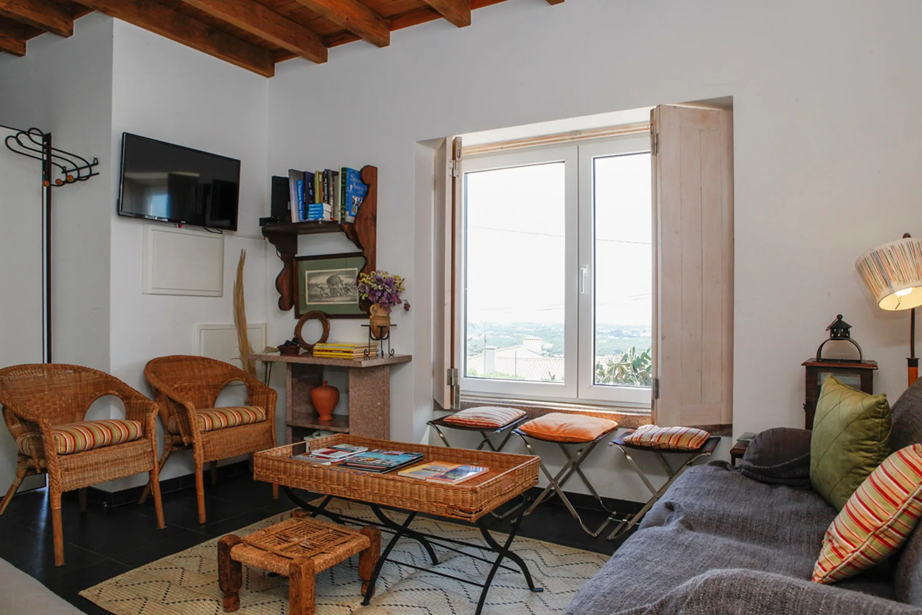 A living room with wicker seating, a coffee table, and a large window.