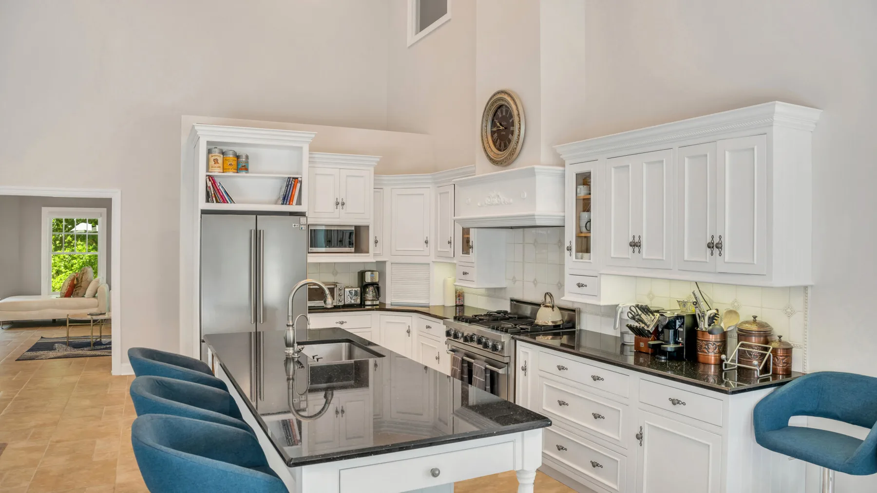 Una cocina luminosa con gabinetes blancos y una isla central.