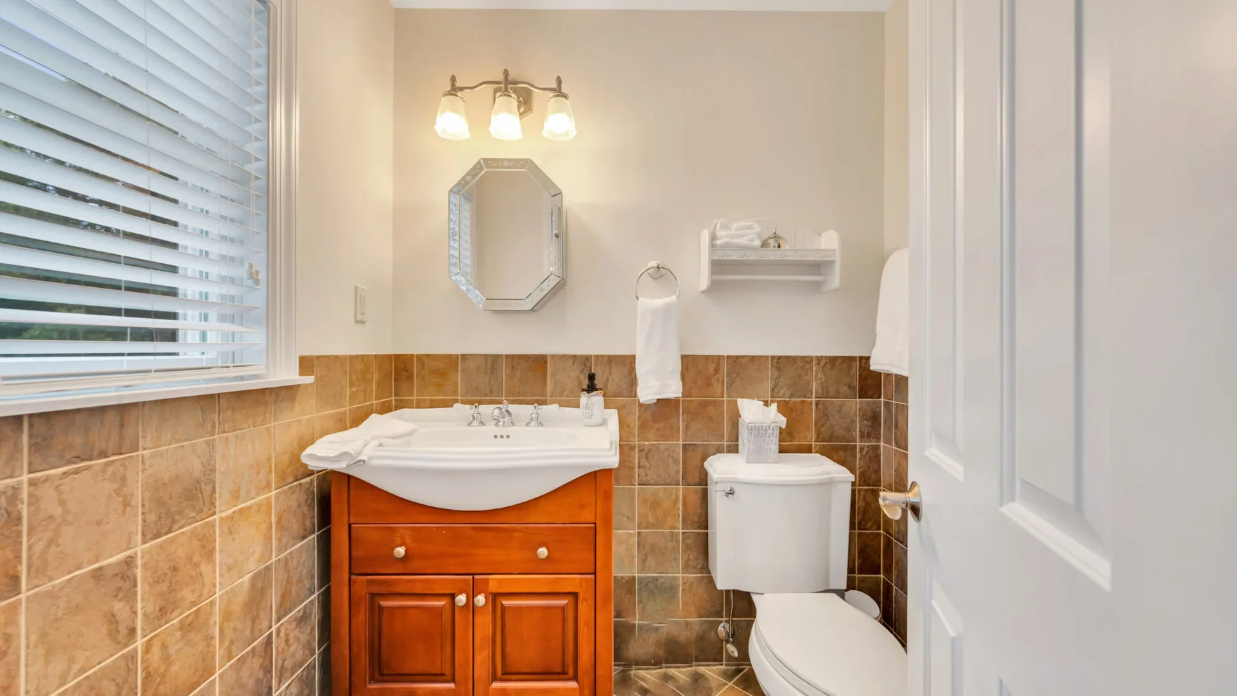 Un baño con lavabo, espejo e inodoro.