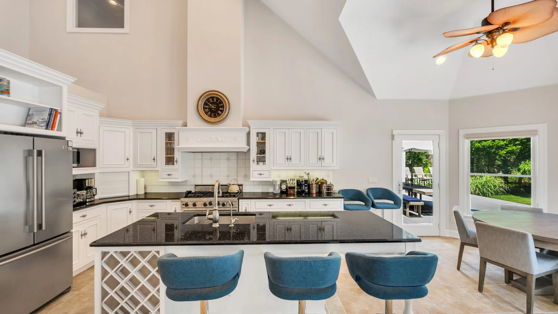 Una cocina luminosa con una isla central y asientos azules.