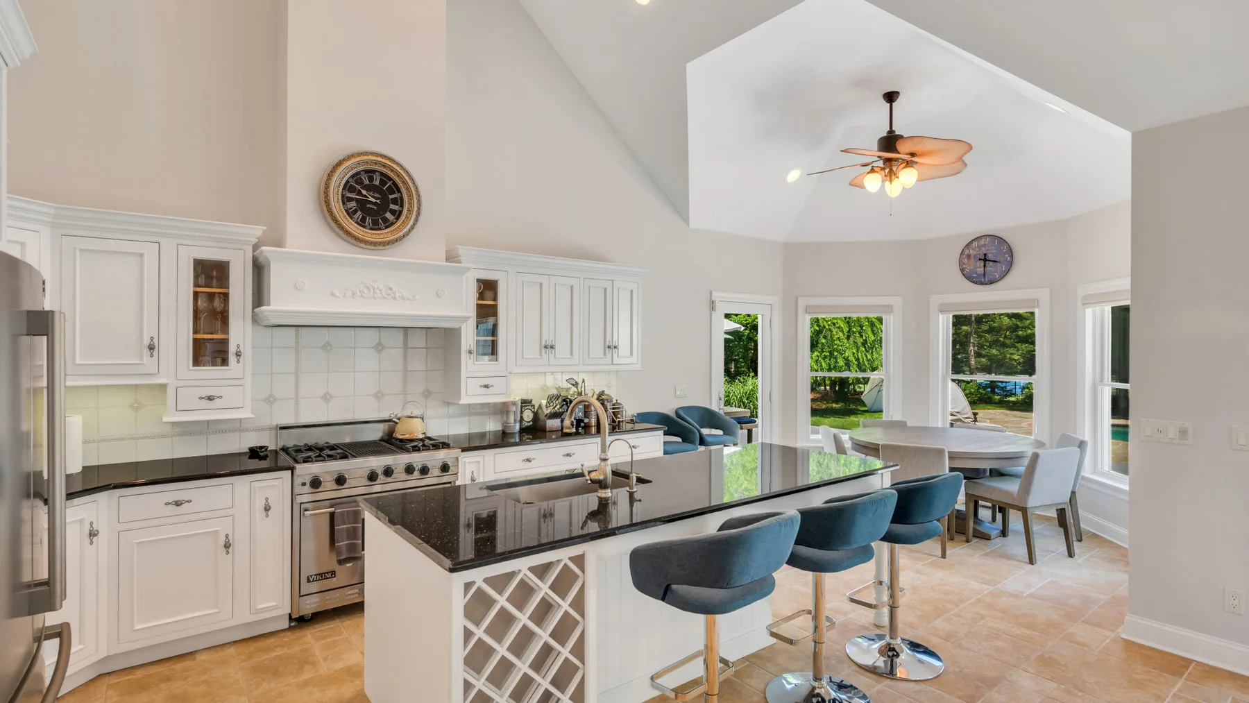 Una cocina luminosa con una isla grande y asientos azules.