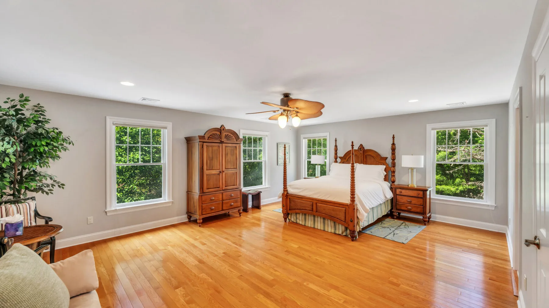 Un dormitorio con una cama de madera, muebles a juego y grandes ventanas.