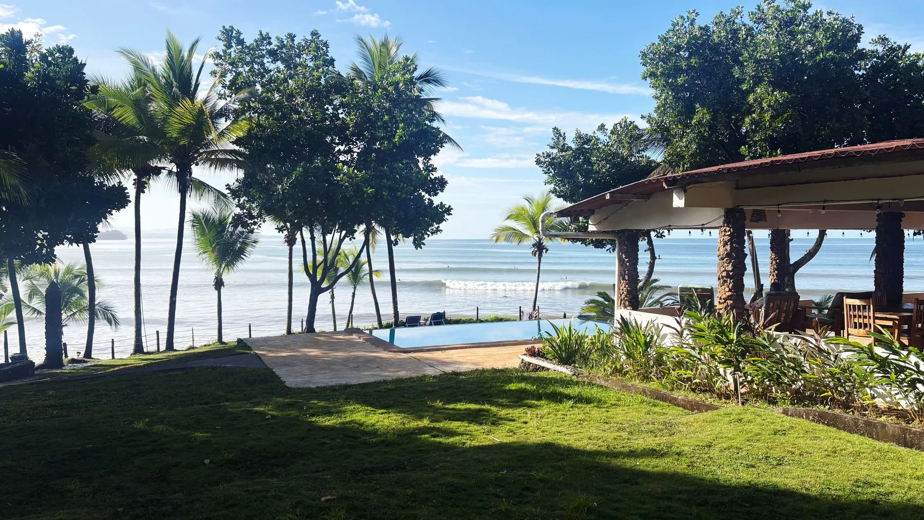 Terraza de una suite con vistas al mar rodeada de un jardín tropical en el Hotel Playa Reina