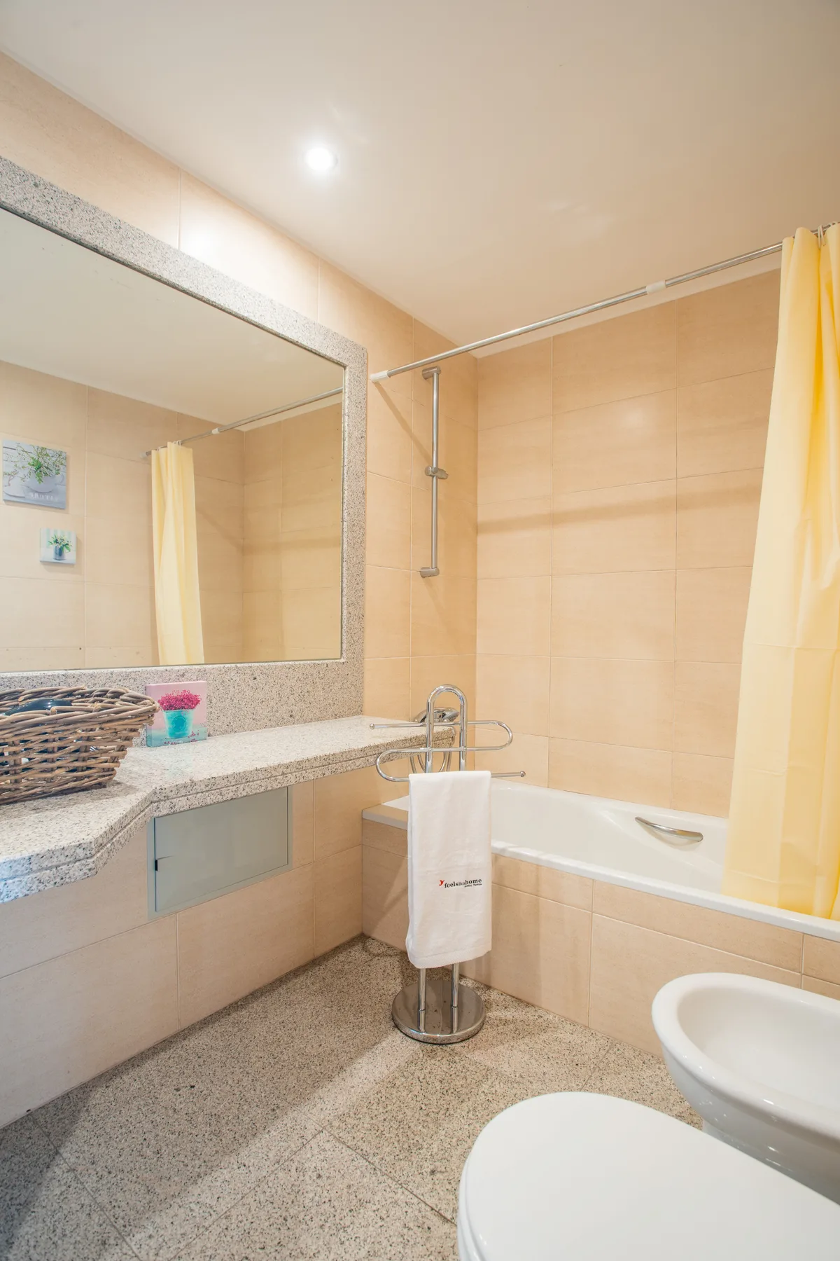 A tiled bathroom with a bathtub, sink, and large mirror.