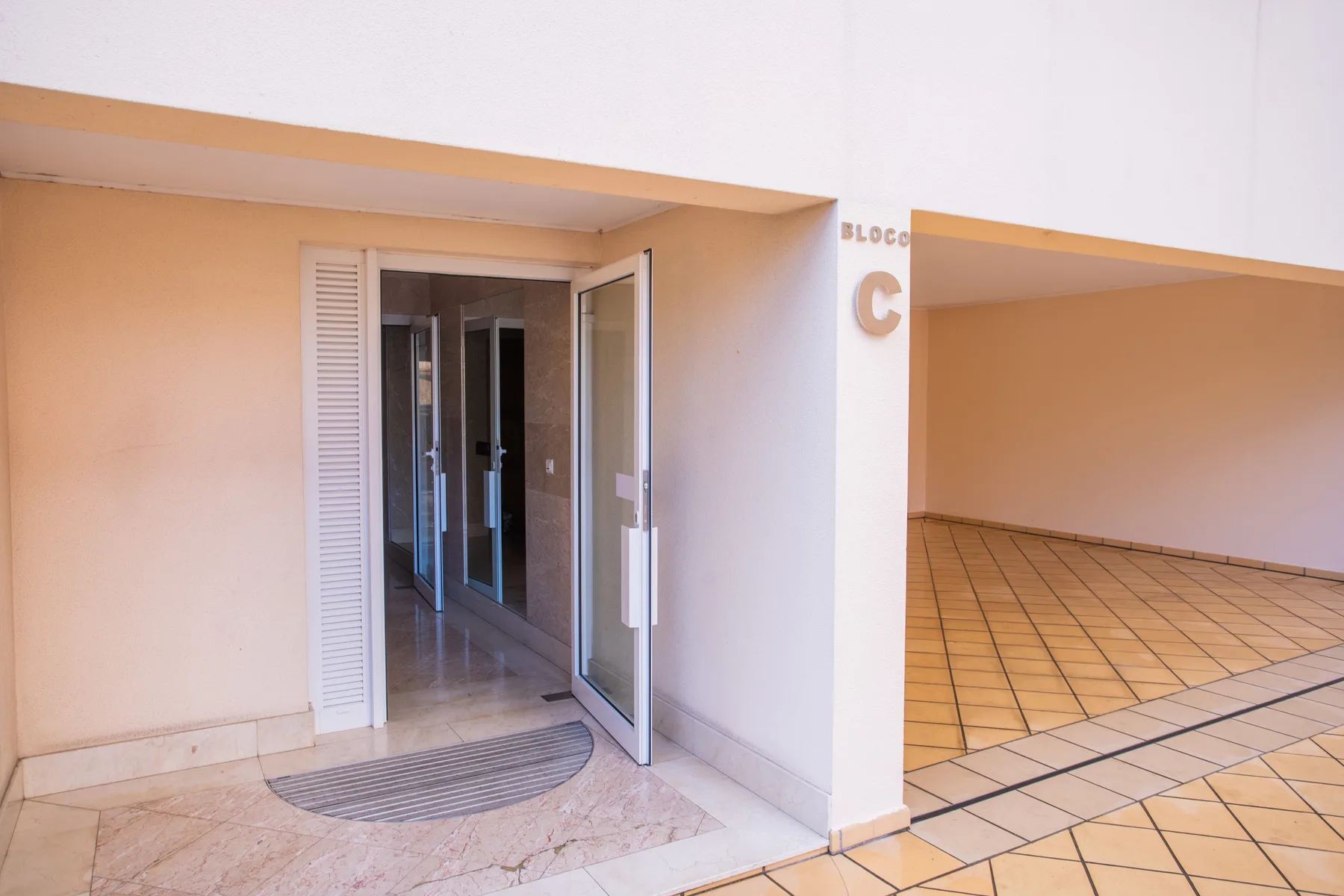An open building entrance faces a tiled covered walkway.