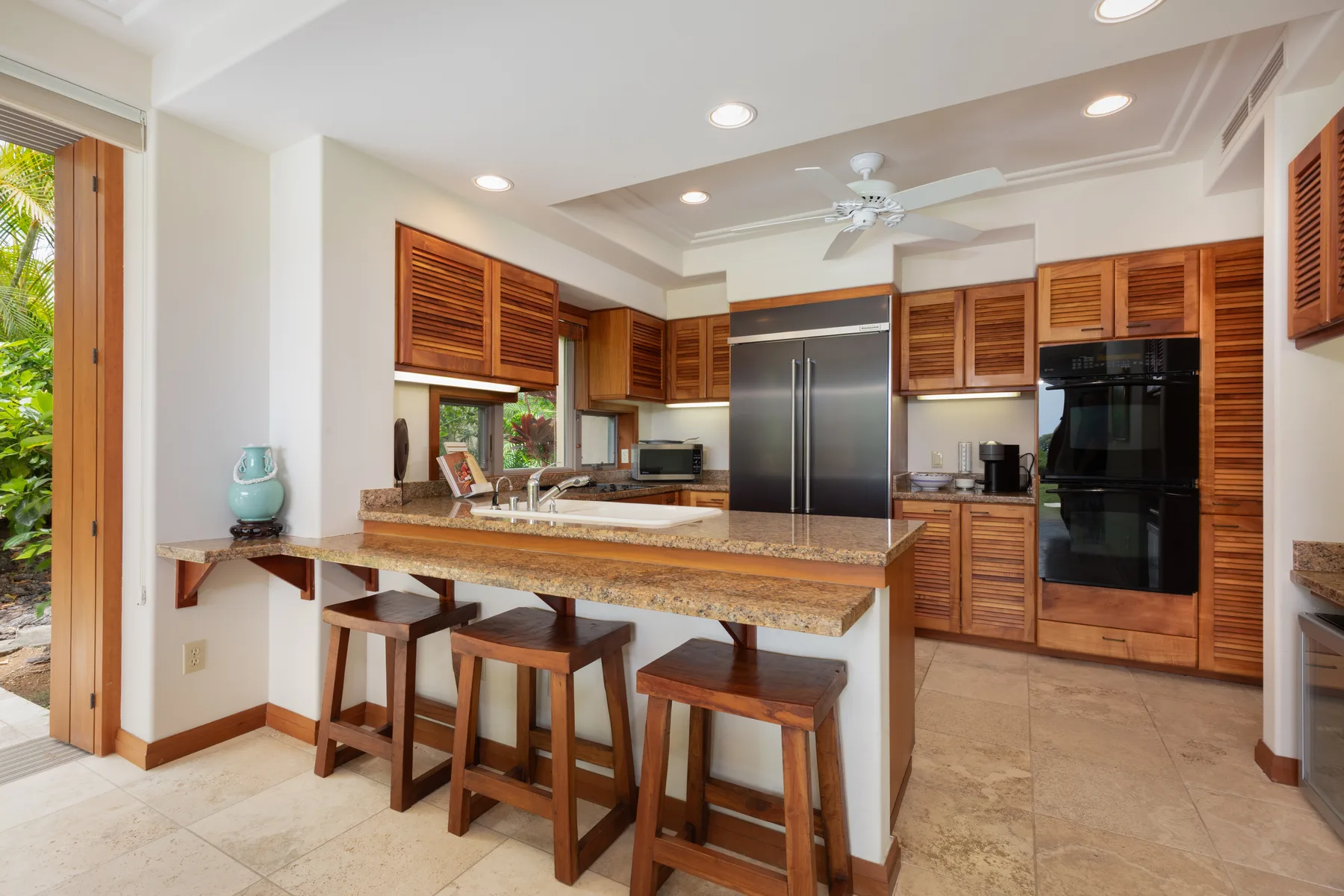 A kitchen with wooden cabinets, stainless steel appliances, and a breakfast counter.