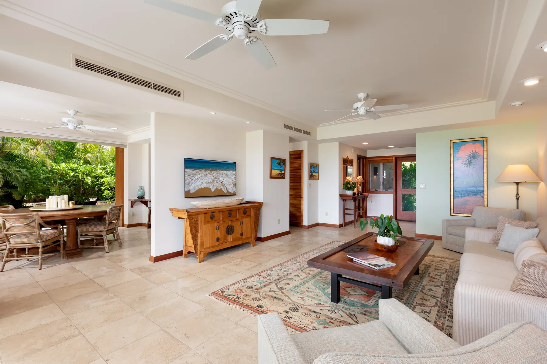 A spacious living room with a seating area, coffee table, and adjoining dining space.