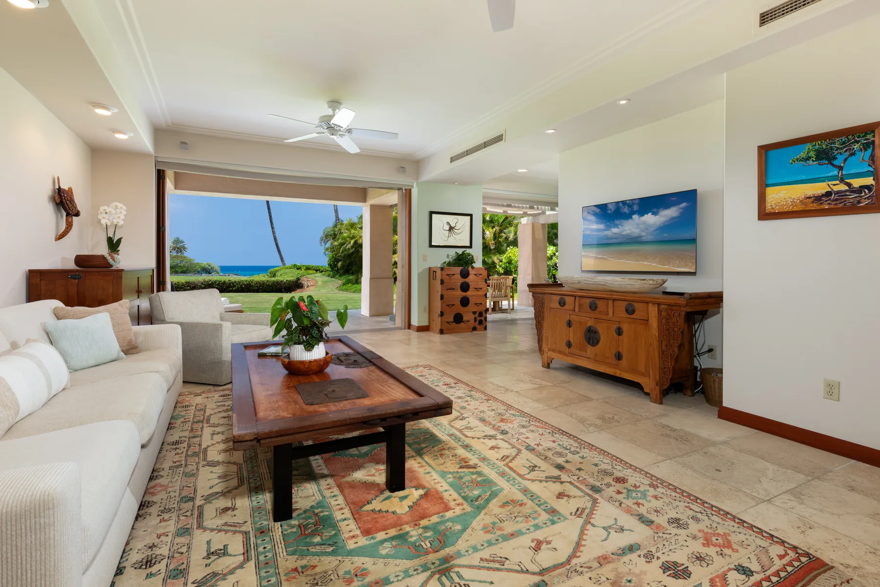 A bright living room with seating, a wooden coffee table, and views of the garden.
