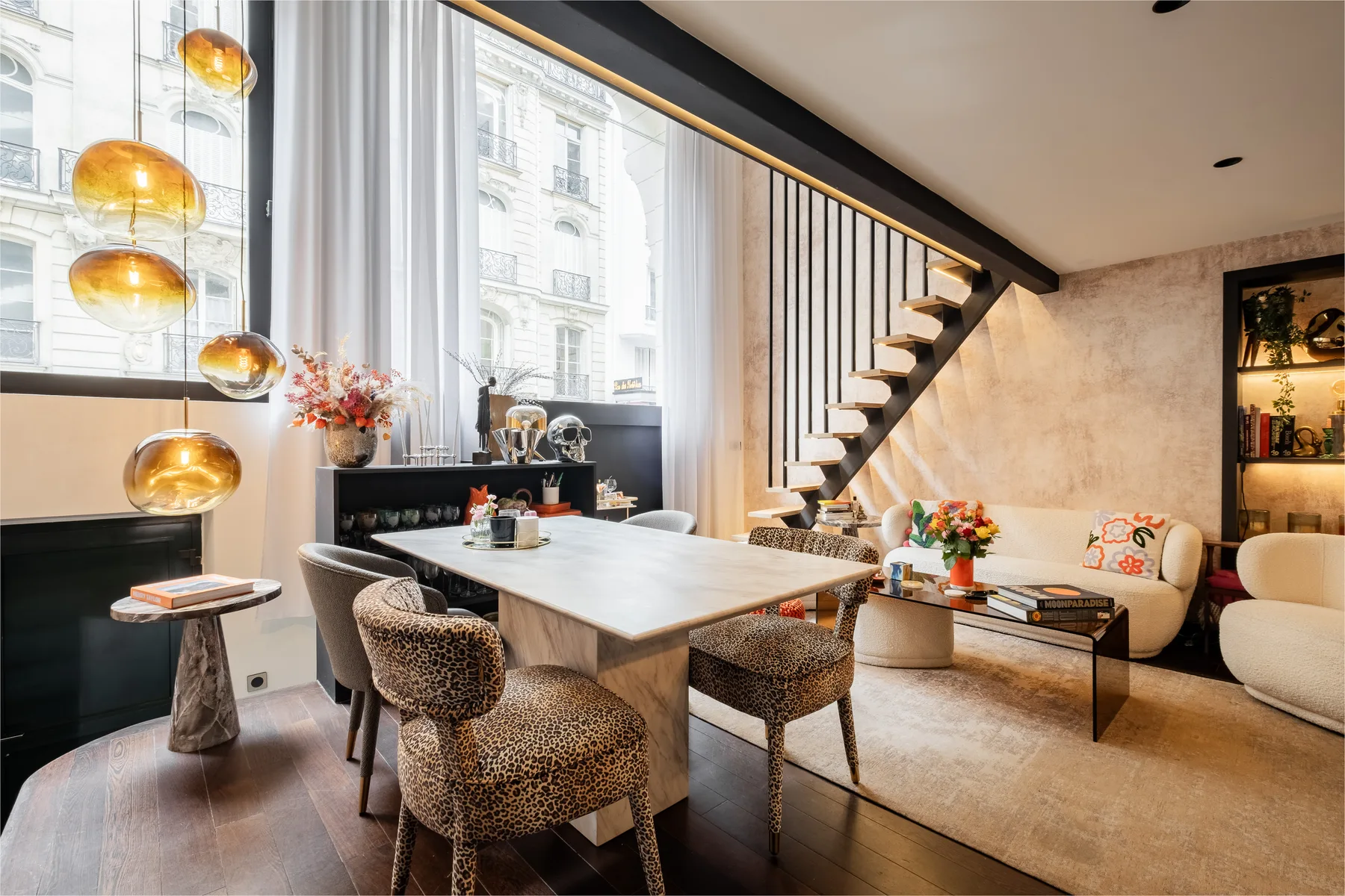A dining area with a table and chairs beside a living room seating area.