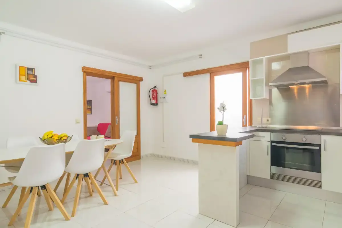 A bright kitchen and dining area with a table beside the kitchen counter.