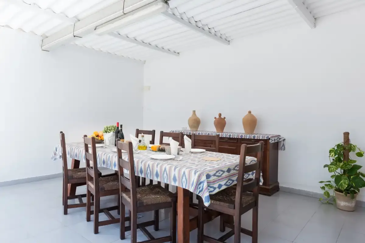 A dining area with a table set with dishes and wooden seating.