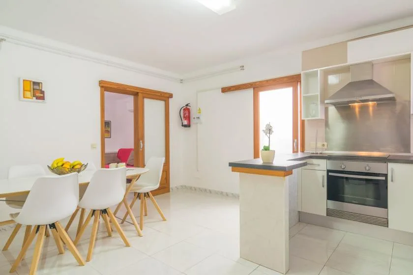A bright kitchen and dining area with a table, seating, and a central counter.