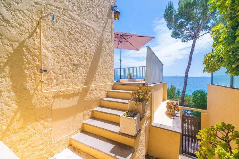 Outdoor steps lead to a terrace overlooking the sea.