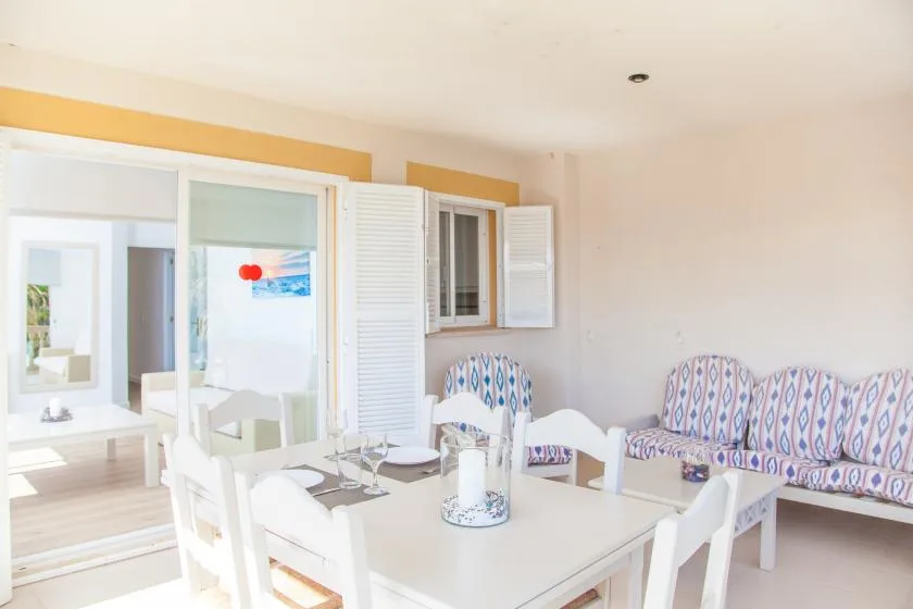 Un comedor luminoso con una mesa blanca y asientos estampados.