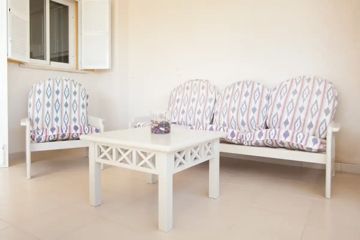 Una luminosa zona de estar con asientos estampados y una mesa de centro blanca.