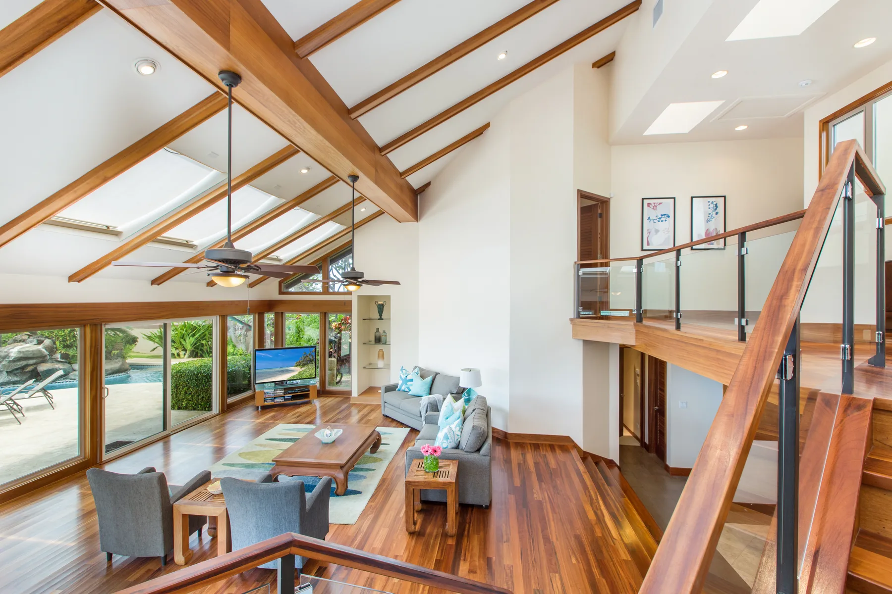 Una sala luminosa con vigas de madera en el techo y grandes ventanas.