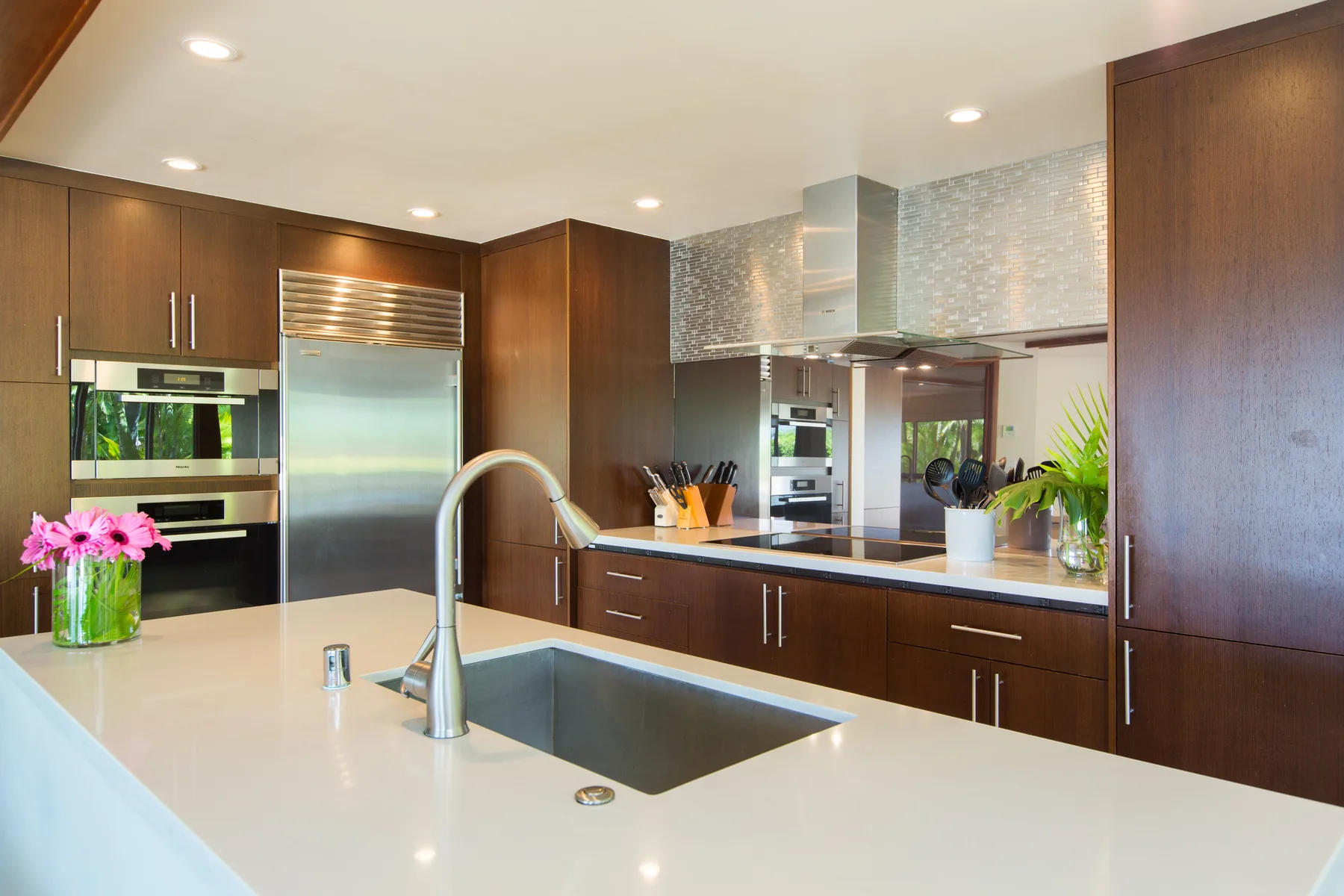 Una cocina moderna con gabinetes de madera oscura y una isla grande con fregadero.