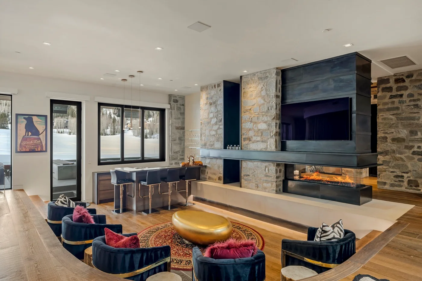 A modern living room features a large fireplace, lounge seating, and a dining area.