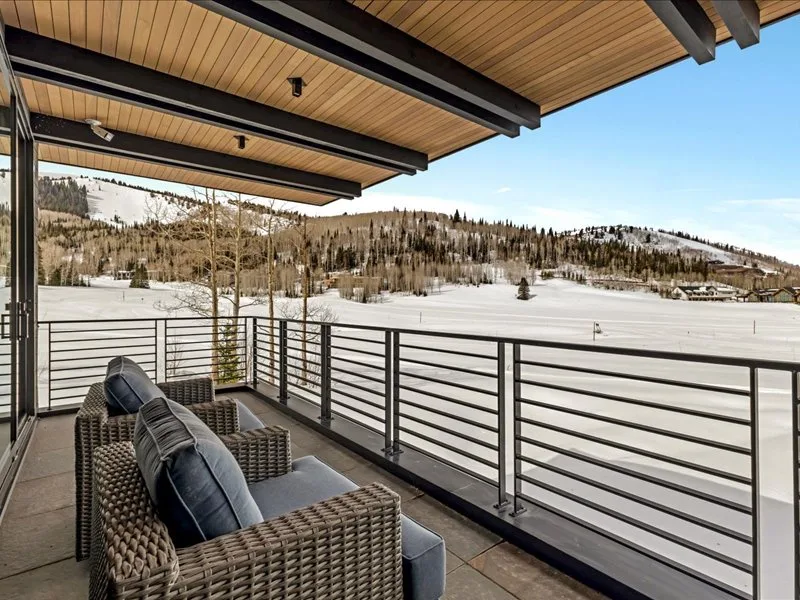 A covered outdoor seating area overlooks a snow-covered landscape.