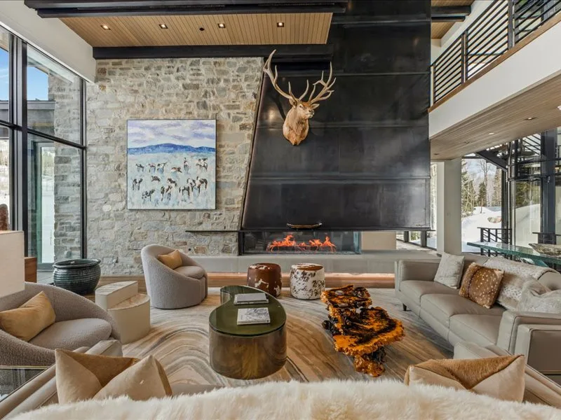 A spacious living room with seating arranged around a large fireplace.