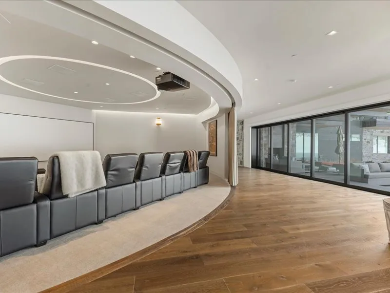 A curved seating area faces large glass windows in a bright modern room.