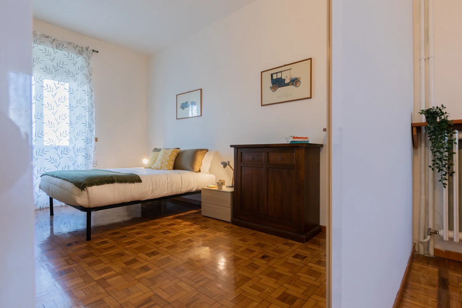 Un dormitorio con una cama, una mesita de noche y un armario oscuro.