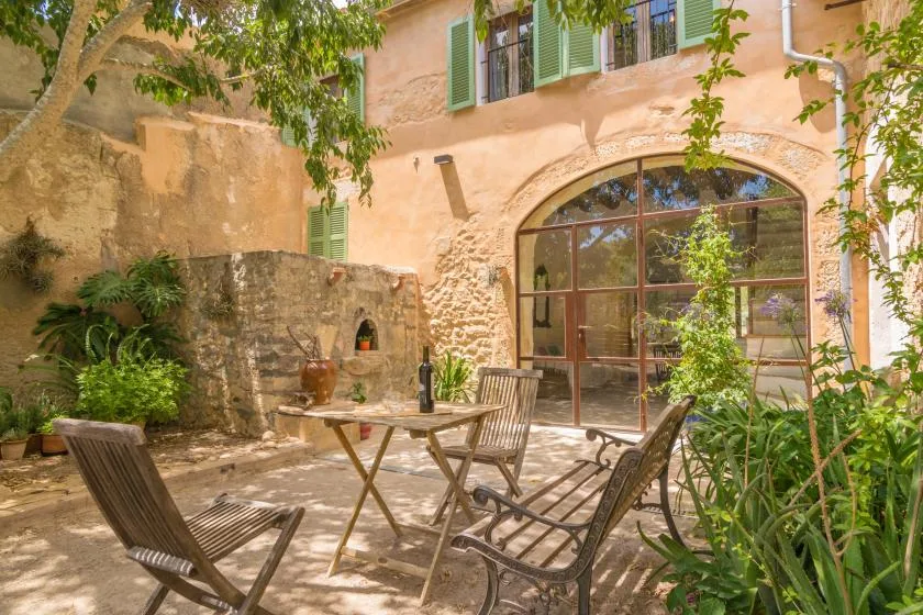 A courtyard patio with outdoor seating and a large arched glass door.