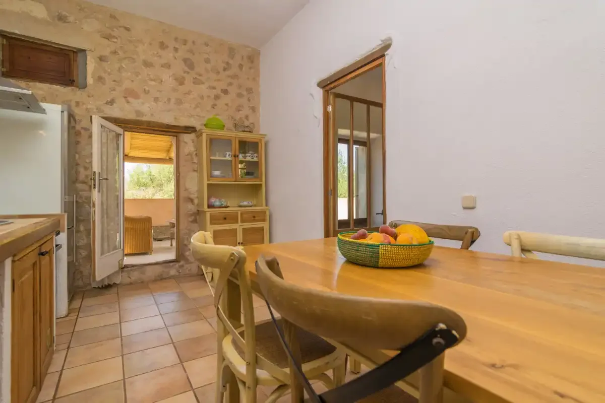 A dining area with a wooden table and stone walls.