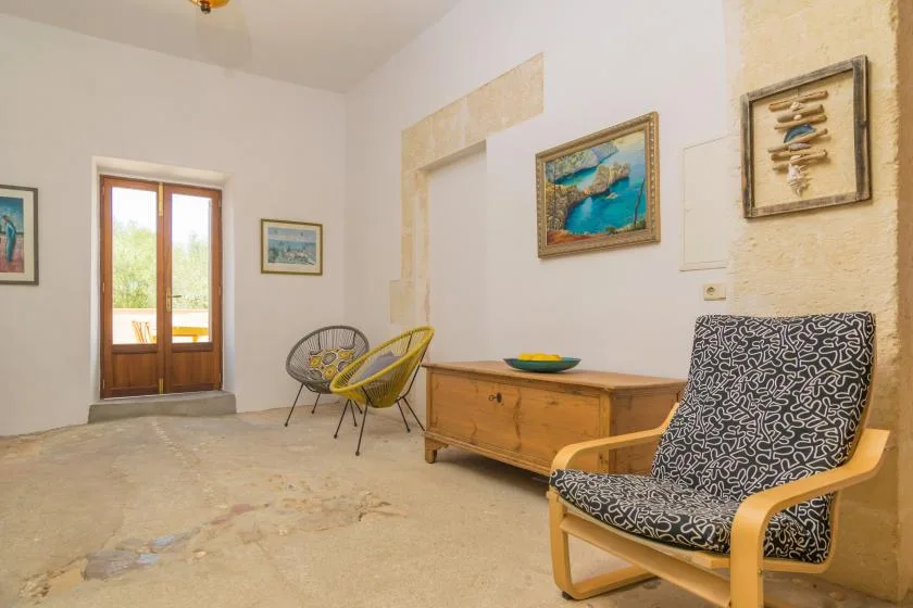 A bright sitting room with a wooden chest and patterned seating.