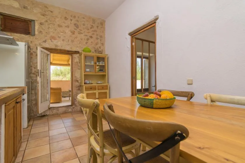 A dining area with a wooden table and chairs beside an open doorway.