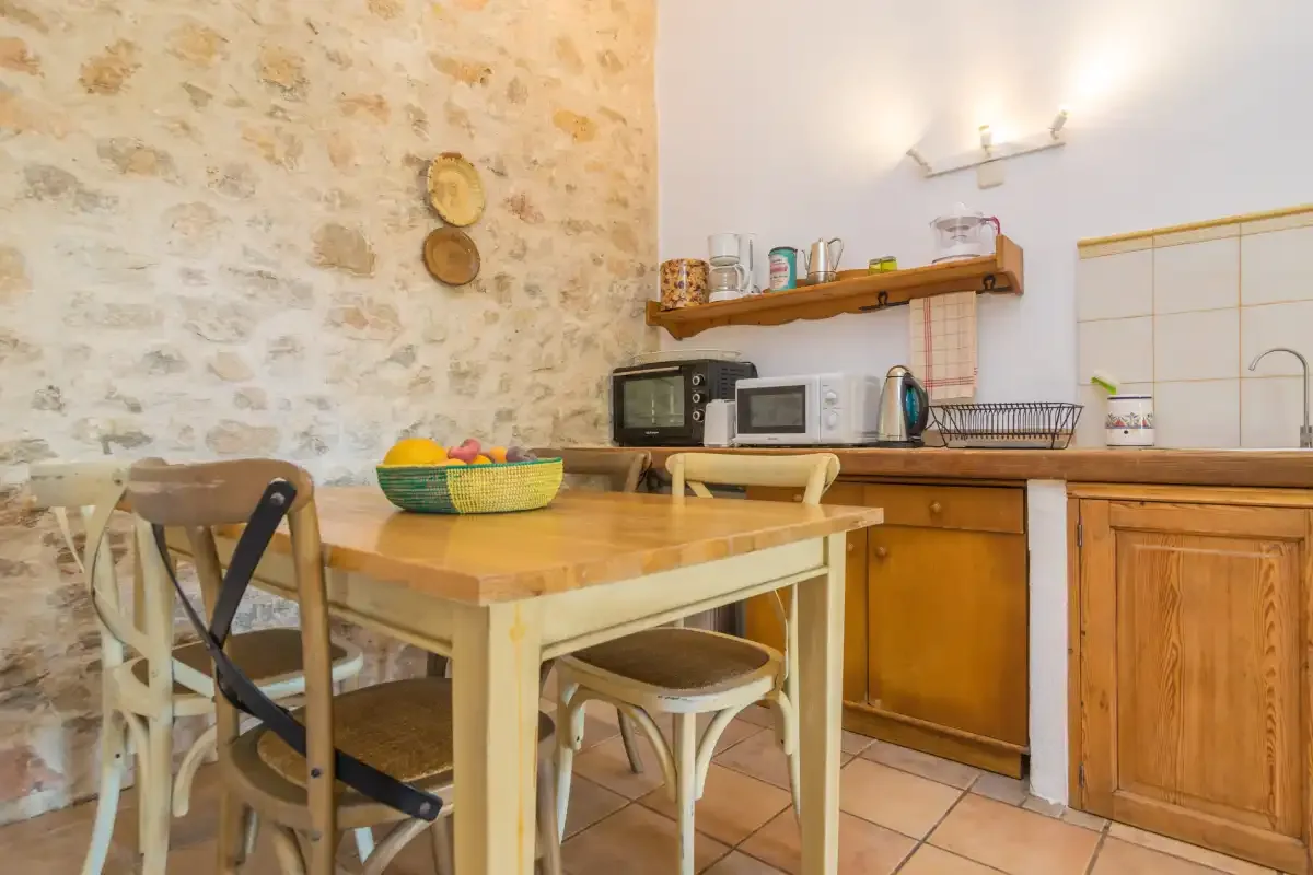 A rustic kitchen with a wooden dining table and countertop appliances.