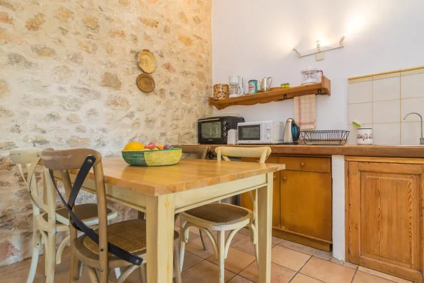 A rustic kitchen with a wooden dining table and countertop appliances.