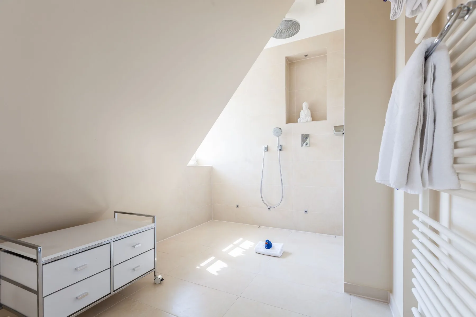 Un baño luminoso con ducha y toallero calefactor.