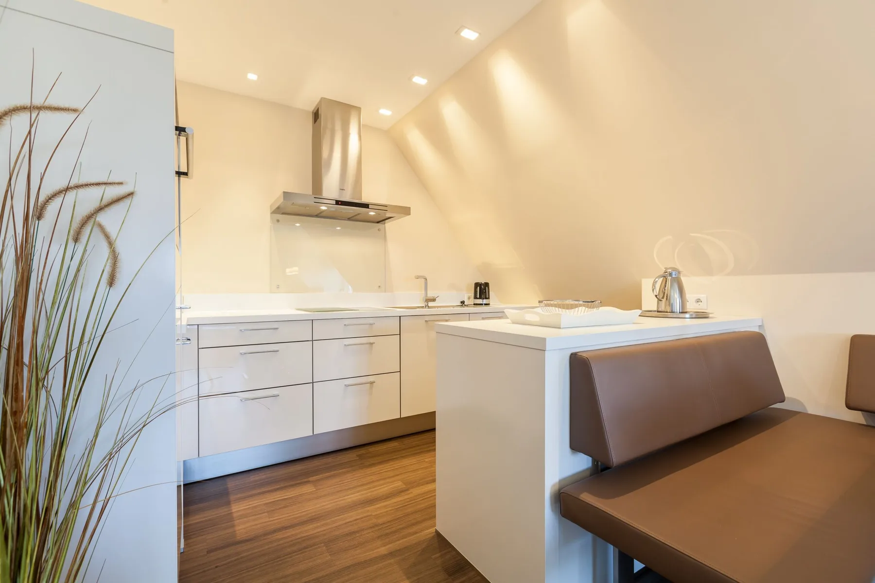 Una cocina luminosa con armarios blancos y una encimera junto a una mesa de comedor.
