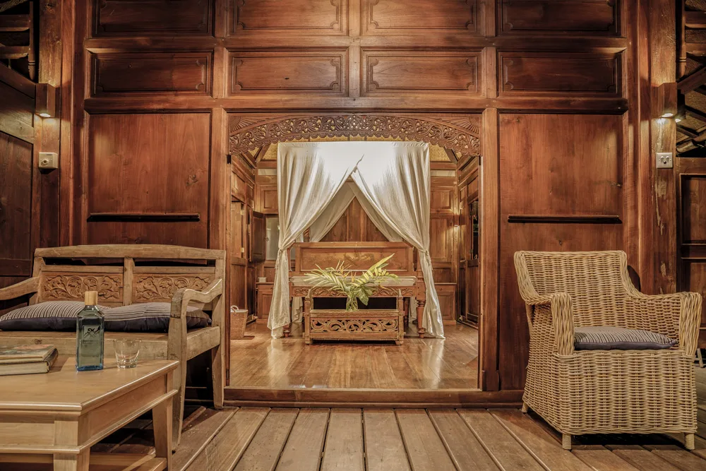 Bungaló de madera de teca con cama con dosel