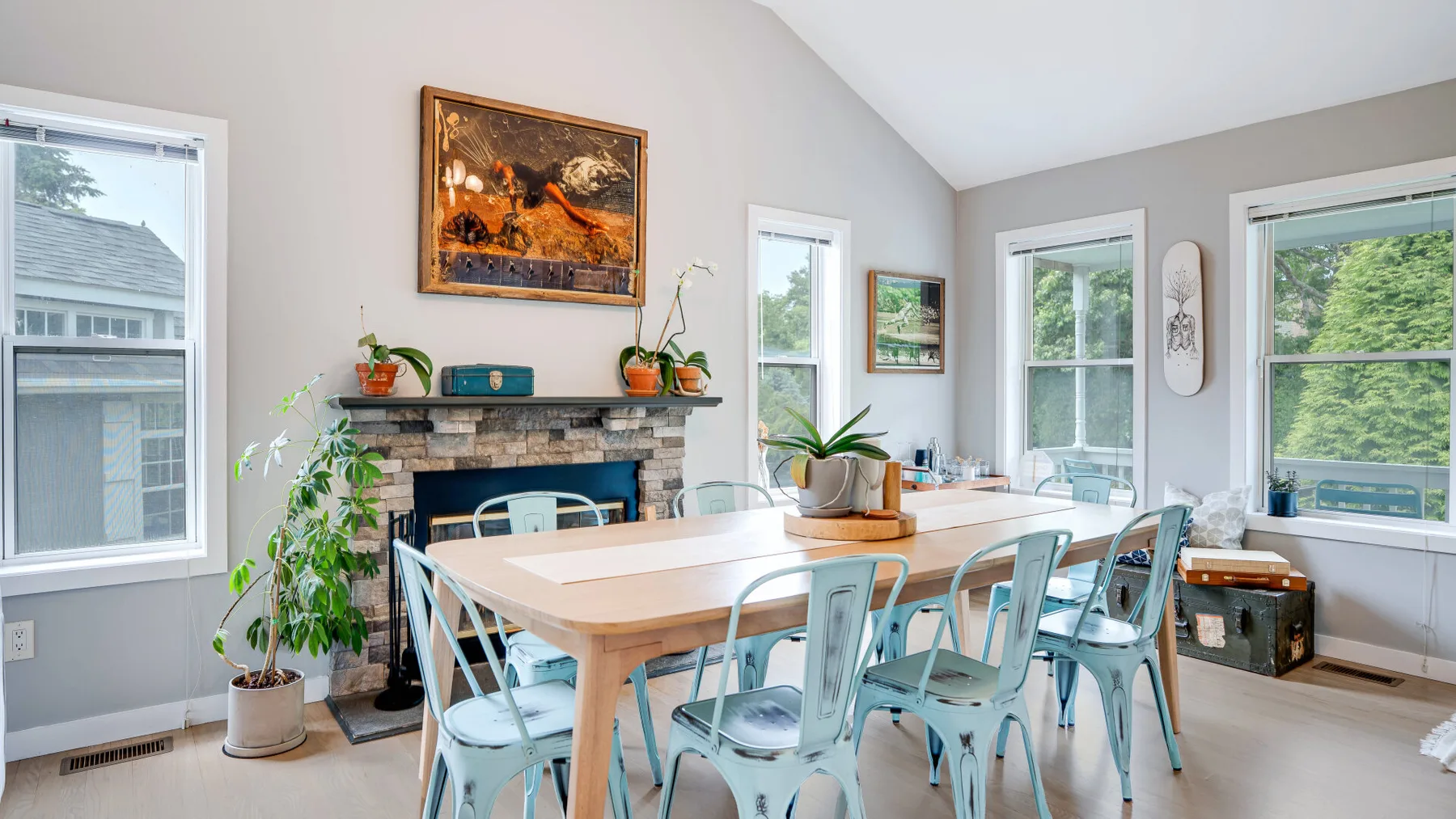 Un comedor luminoso con una mesa larga y grandes ventanas.