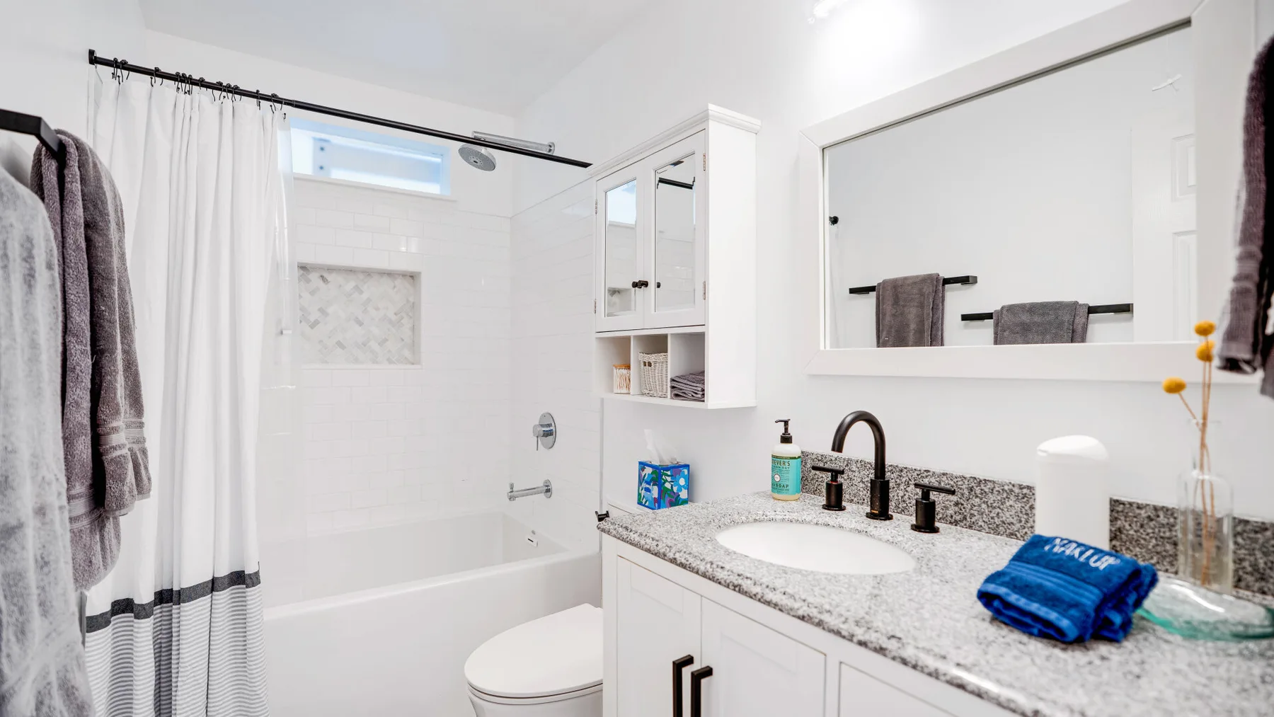 Un baño luminoso con bañera, lavabo y espejo de pared.